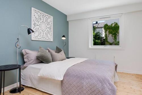 Un dormitorio con una cama grande y una ventana en Beautiful apartment in the middle of Lillehammer., en Lillehammer