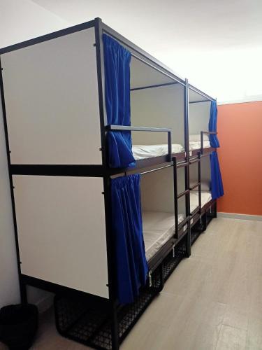 a room with two bunk beds with blue curtains at Palma Port Hostel - Albergue Juvenil in Palma de Mallorca