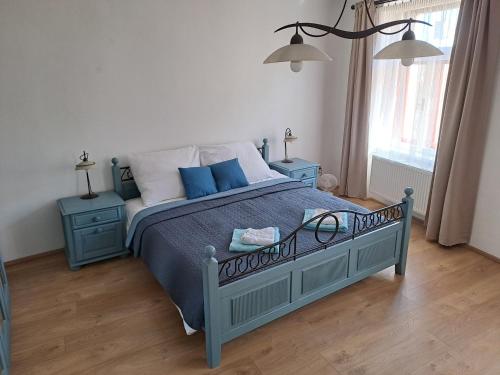 a bedroom with a blue bed and two night stands at Řehořův dům in Jihlava