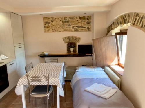 カステルヌオーヴォ・マグラにあるCasa Dell'Angeloのベッドとテーブル付きの小さな部屋
