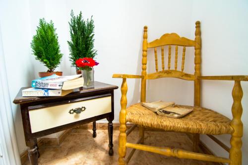 a chair and a table with books and a plant at San José Guest House in Granada