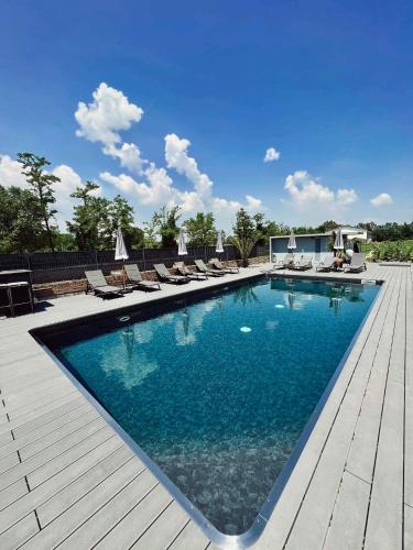 a large swimming pool with lounge chairs on a wooden deck at RESIDENCE BACO Da SETA in Mestre