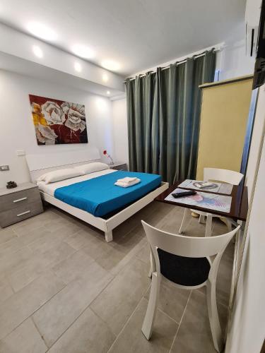a bedroom with a bed and a desk and a table at Caravel Appartamentini in Lido di Camaiore