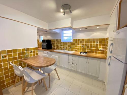une cuisine avec une table, des chaises et un réfrigérateur dans l'établissement A louer haut de villa 4 pièces à Sainte-Maxime Golfe de St-Tropez, à Sainte-Maxime