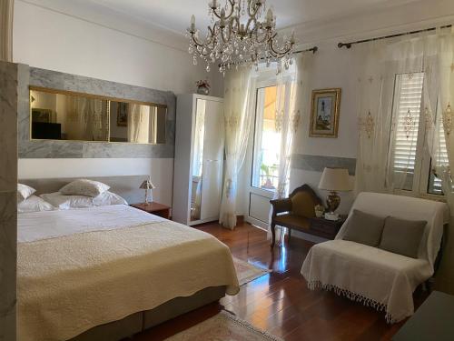 a bedroom with a bed and a chair and a chandelier at Studio Apartment Naya in Mali Lošinj