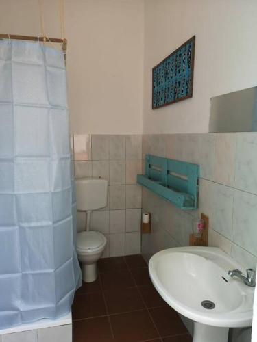 a bathroom with a white sink and a toilet at Old house in Tarrafal