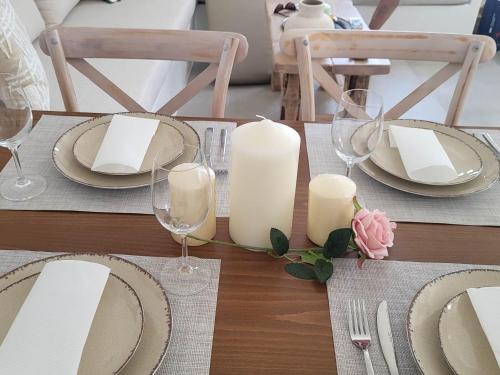 a wooden table with plates and candles on it at Stavros Residence in Mármara