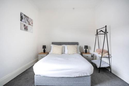 - une chambre avec un lit blanc et une chaise dans l'établissement The Crown, Modern and Stylish Home from Home, à Darlington