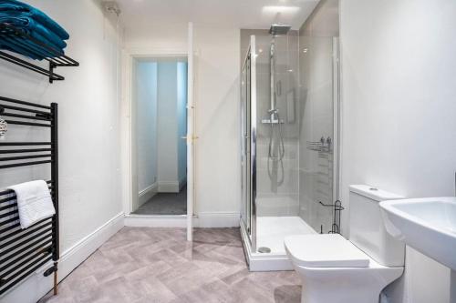a bathroom with a shower and a toilet and a sink at The Crown, Modern and Stylish Home from Home in Darlington
