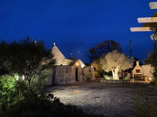 an old building with a yard at night at Trullo Raimondo in Martina Franca