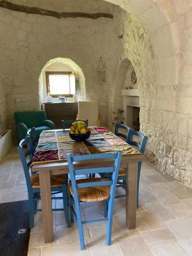 a table with chairs and a bowl of fruit on it at Trullo Raimondo in Martina Franca