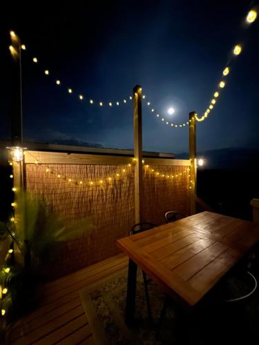 una terraza con una mesa de madera y luces de cuerda en Angostura Oasis en Hot Springs