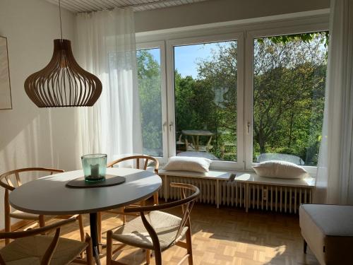 ein Esszimmer mit einem Tisch und Stühlen sowie einem großen Fenster in der Unterkunft Haus Falkenweg 5 Ferienhaus Falkenweg in Scharbeutz