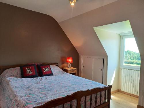 a bedroom with a bed with red pillows and a window at Maison de 3 chambres avec jardin amenage et wifi a Saint Alban a 3 km de la plage in Saint-Alban