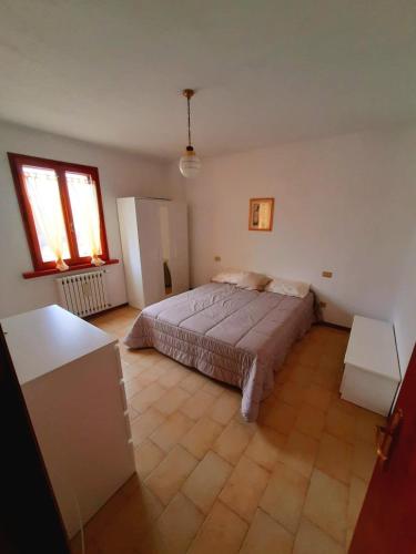 una camera con un grande letto e due finestre di appartamento Sant'Agata feltria a SantʼAgata Feltria