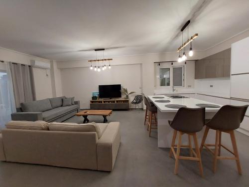 a living room and kitchen with a couch and a table at New minimal apartment,10' from Athens airport in Spáta