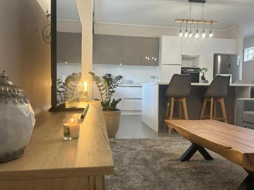 a kitchen and a living room with a wooden table at New minimal apartment,10' from Athens airport in Spáta