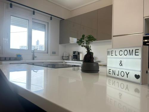 a white kitchen with a potted plant on a counter at New minimal apartment,10' from Athens airport in Spáta