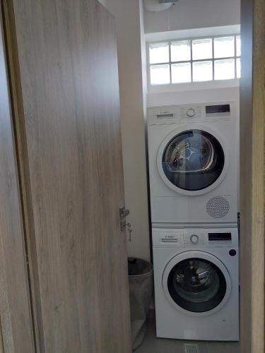 a washing machine and a washer and dryer in a room at New minimal apartment,10' from Athens airport in Spáta