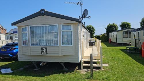 a tiny house sitting on a ramp in a yard at Serendipity Caravan Hire in Chapel Saint Leonards