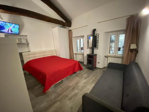 a living room with a red bed and a couch at Casa Danilo in Cadegliano Viconago