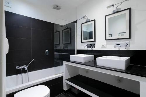 a black and white bathroom with two sinks and a toilet at 06A4 - Situation exceptionnelle au Port de Nice in Nice