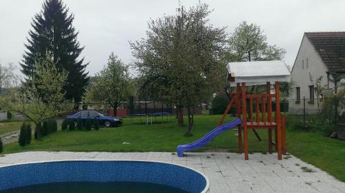 a playground with a slide next to a pool at Ubytování Macků in Spolí