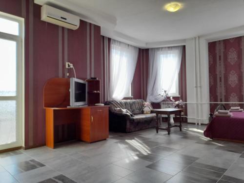 a living room with a couch and a tv at SunLake Hotel Osokorki in Kyiv