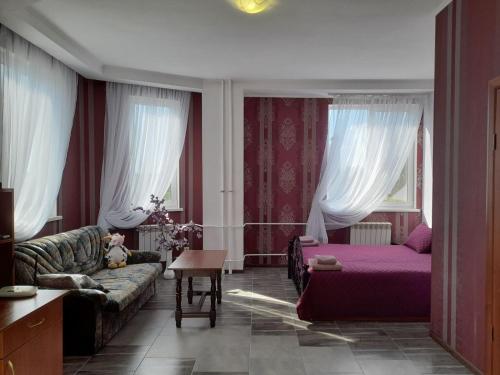 ein Wohnzimmer mit einem Sofa und einem Bett in der Unterkunft SunLake Hotel Osokorki in Kiew