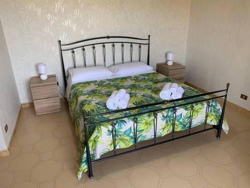 1 dormitorio con 1 cama con toallas en Casa Vacanza Torre di Mezzo - Tramonto, en Marausa