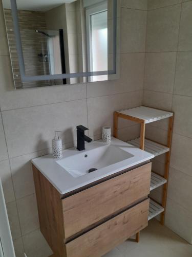 W łazience znajduje się umywalka i lustro. w obiekcie Apartamentos aguanaz w mieście Entrambasaguas