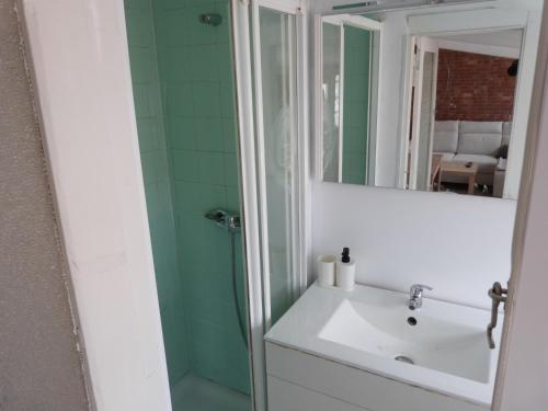 a bathroom with a sink and a shower with a mirror at San Antonio Suites Vitoria in Vitoria-Gasteiz