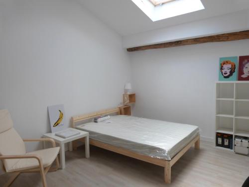 1 dormitorio con 1 cama y 1 silla en San Antonio Suites Vitoria, en Vitoria-Gasteiz