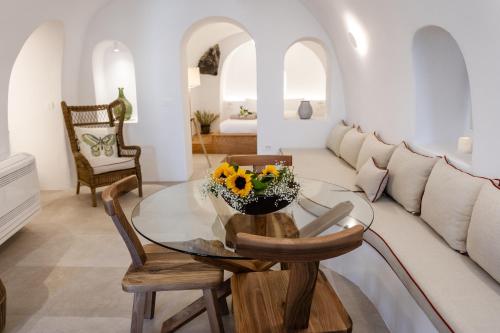 a living room with a glass table and a couch at Oia Mare Villas in Oia