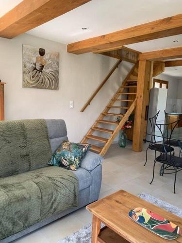 a living room with a couch and a staircase at Chez Camille aux Sieges in Les Rives