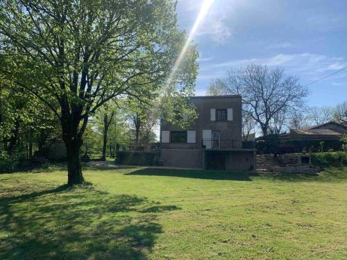 a house in a field with a tree in front of it at Chez Camille aux Sieges in Les Rives