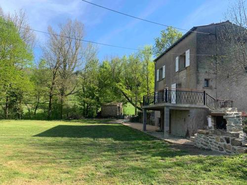an old brick building with a balcony on a yard at Chez Camille aux Sieges in Les Rives