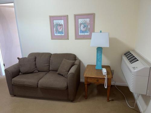 a living room with a couch and a table with a lamp at Sea Scape Beach and Golf Villas in Kitty Hawk
