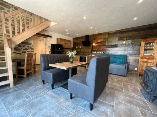 une salle à manger avec une table et des chaises en bois dans l'établissement Maison d'hôte avec sauna et jacuzzi à la campagne, à Les Portes du Coglais