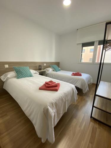 a bedroom with two beds with red towels on them at Apartamento NyA Zamora in Zamora