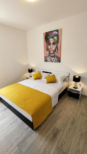 a bedroom with a large bed with a painting on the wall at Feel Good View in Trogir