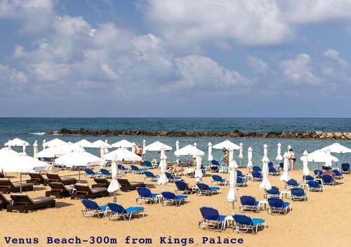 a beach with chairs and umbrellas and the ocean at 105 Kings Palace - Fabulous 2 Bed, 2 bath, Large Patio with Garden - Sea Views in Paphos City