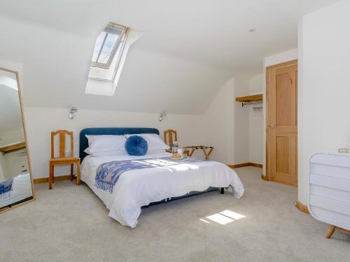1 dormitorio con 1 cama con cabecero azul en Finch Cottage, en Farnborough