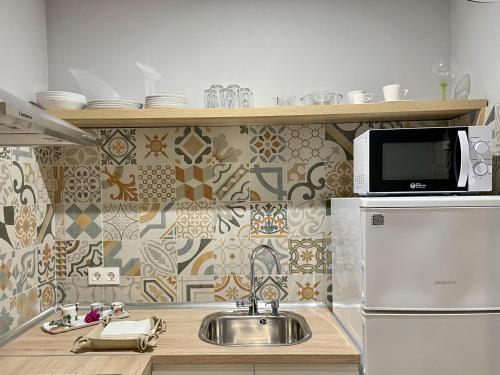 a kitchen with a sink and a microwave at Apartamentos MadreSelva in Fernán Pérez