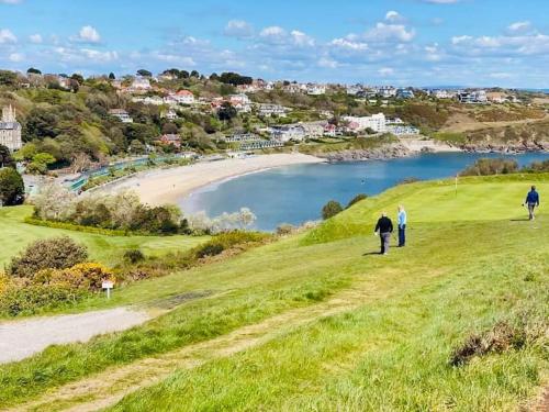 people walking on a hill near a beach at The Lodge Annex - immaculate coastal property in Oystermouth