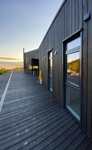 a wooden boardwalk leading to a building with windows at Senjavista, near nature, sea and mighty mountains in Skaland