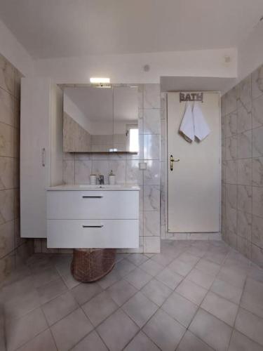 a bathroom with a sink and a door with a mirror at Giannata House in Argostoli