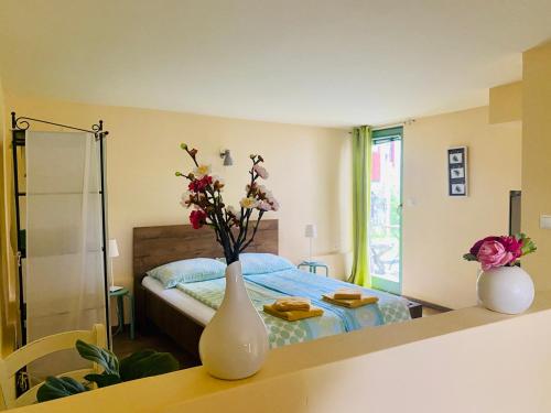 Un dormitorio con una cama y un jarrón con flores. en Apartments Olga, en Bled