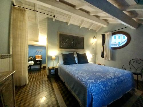a bedroom with a blue bed in a room with a desk at La Casa Rosa in Pigna