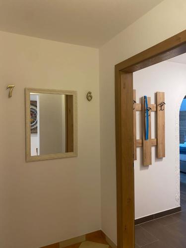 a bathroom with a mirror and a door with a window at Appartements-Dalila in Sankt Michael im Lungau